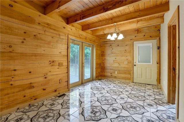 entryway with french doors, light tile patterned floors, wooden walls, and beam ceiling