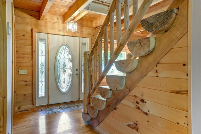 foyer featuring beam ceiling, wood walls, wood ceiling, and hardwood / wood-style flooring