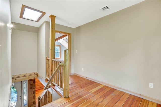 empty room with a skylight and wood-type flooring