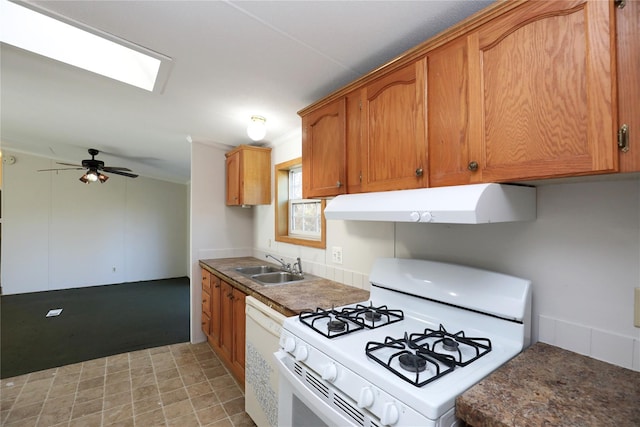 kitchen featuring ceiling fan, white appliances, sink, and a skylight