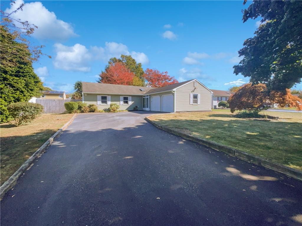 ranch-style home with a garage and a front yard