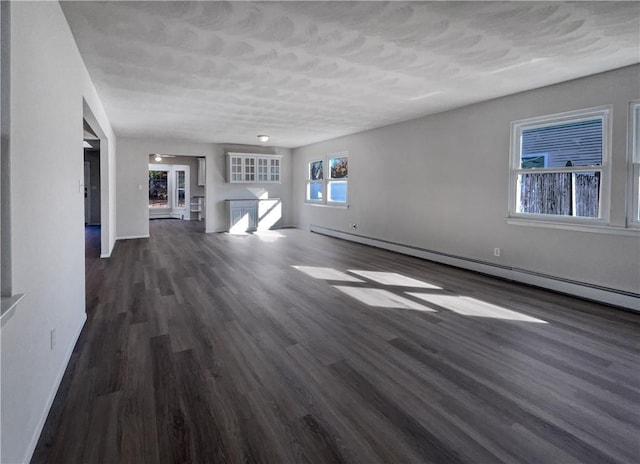 unfurnished living room featuring baseboard heating and dark wood-type flooring