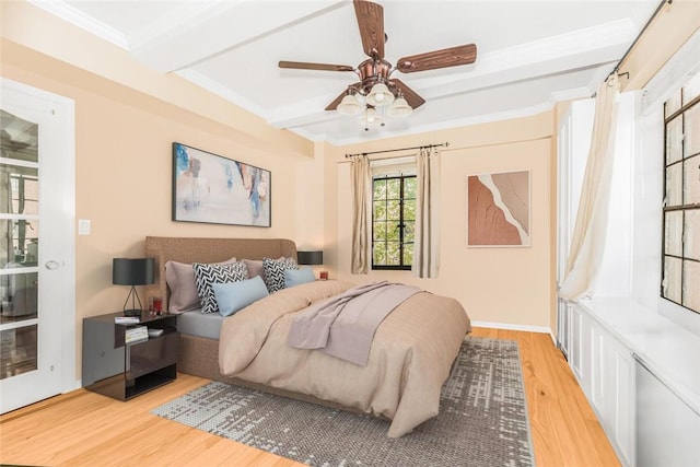 bedroom featuring ceiling fan, beam ceiling, ornamental molding, and light hardwood / wood-style flooring