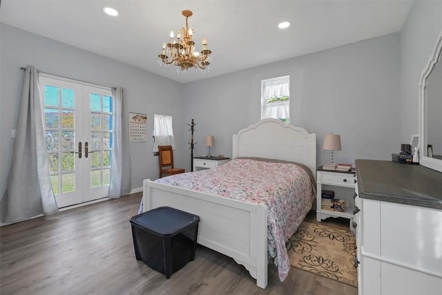 bedroom featuring multiple windows, french doors, dark wood-type flooring, and an inviting chandelier