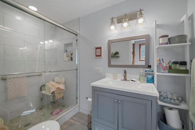 bathroom featuring hardwood / wood-style flooring, vanity, toilet, and an enclosed shower