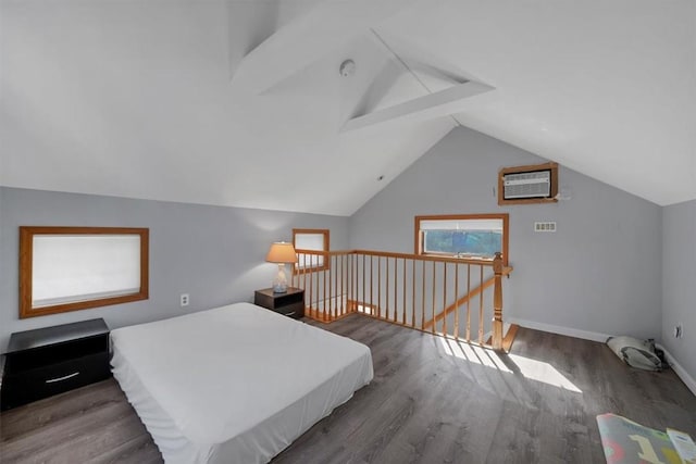 bedroom featuring wood-type flooring, an AC wall unit, and vaulted ceiling