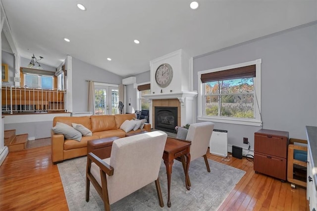 living room featuring a fireplace, light hardwood / wood-style flooring, and lofted ceiling