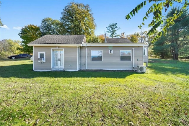 rear view of property with ac unit, a yard, and cooling unit