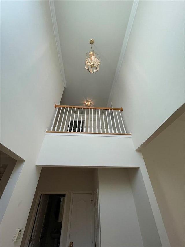 stairs with crown molding and a high ceiling