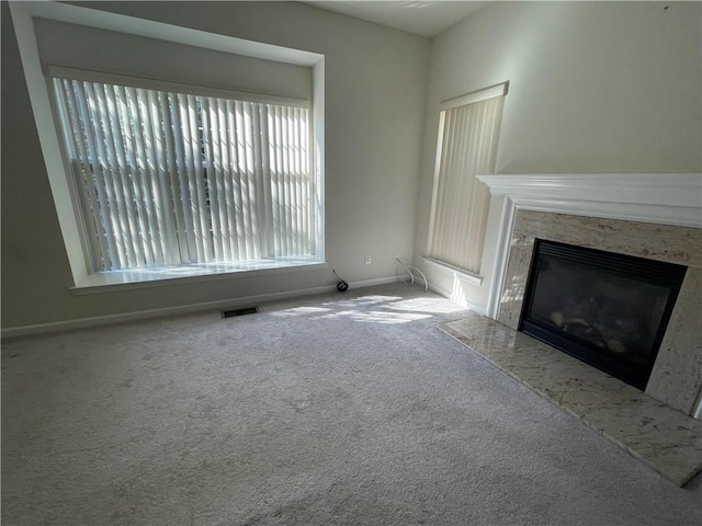 unfurnished living room with a fireplace and carpet flooring