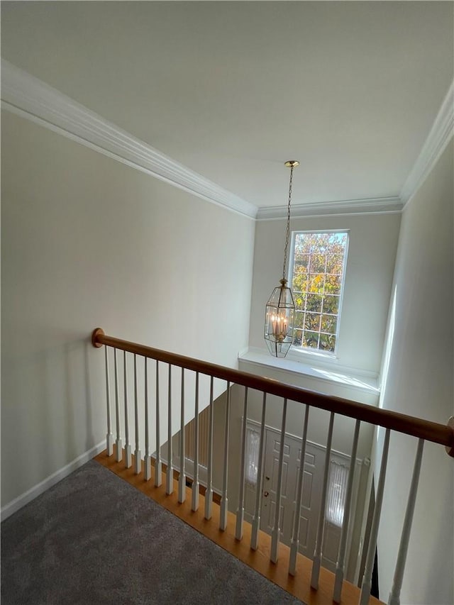 staircase featuring carpet, ornamental molding, and a chandelier