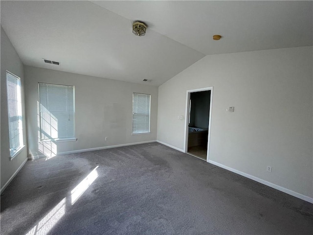 carpeted spare room featuring lofted ceiling