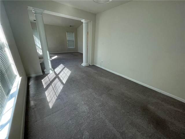 carpeted empty room featuring ornate columns