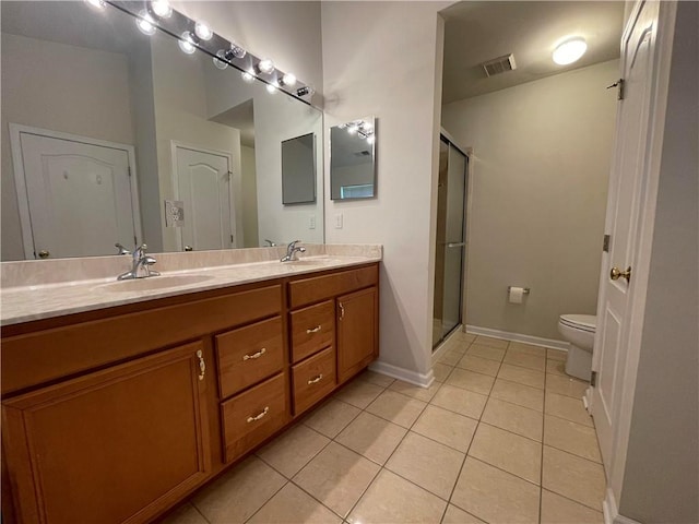 bathroom featuring tile patterned floors, vanity, toilet, and a shower with shower door