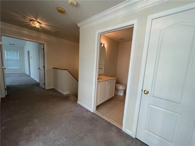 hallway with dark carpet and ornamental molding