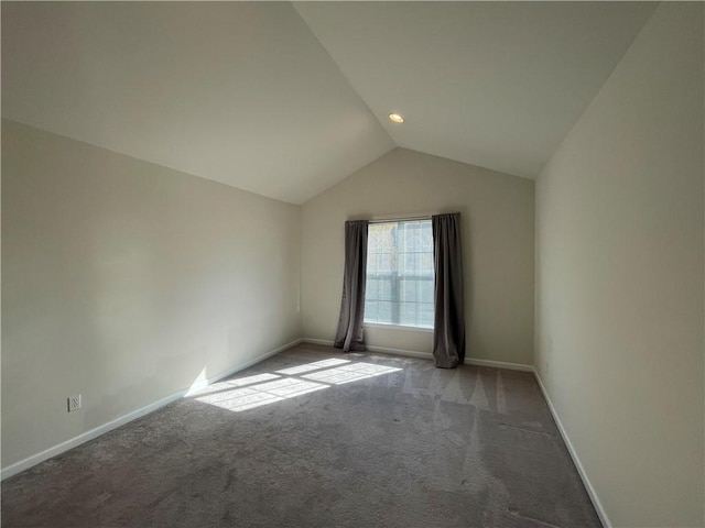 carpeted empty room with lofted ceiling