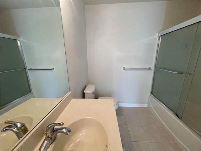 full bathroom featuring tile patterned floors, sink, enclosed tub / shower combo, and toilet