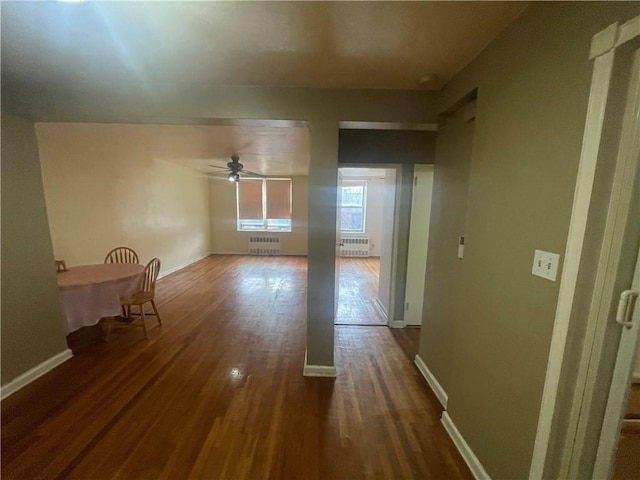 interior space with ceiling fan, dark hardwood / wood-style flooring, and radiator heating unit