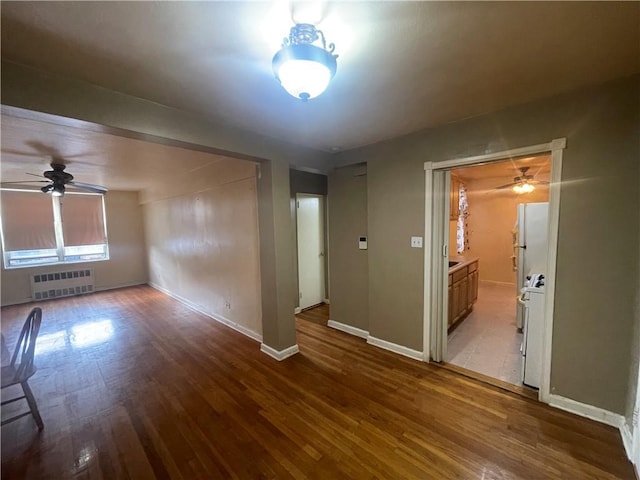 empty room with radiator heating unit and hardwood / wood-style floors