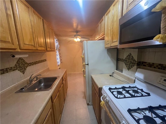 kitchen featuring ceiling fan, sink, tasteful backsplash, white range with gas stovetop, and light tile patterned flooring