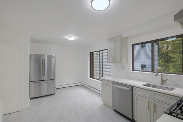 kitchen featuring appliances with stainless steel finishes, backsplash, gray cabinetry, and sink