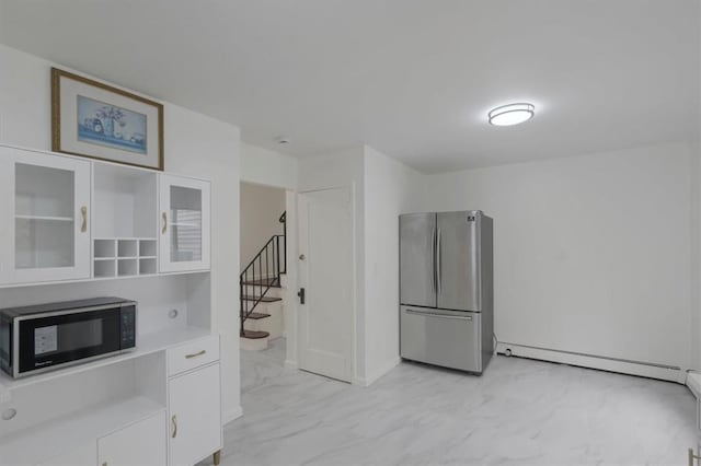 kitchen with white cabinets, stainless steel fridge, and a baseboard radiator