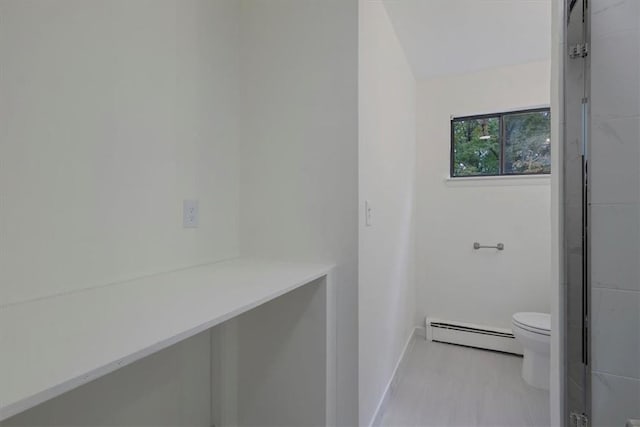 bathroom featuring toilet and a baseboard heating unit