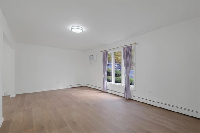 empty room with light wood-type flooring and a wall mounted AC