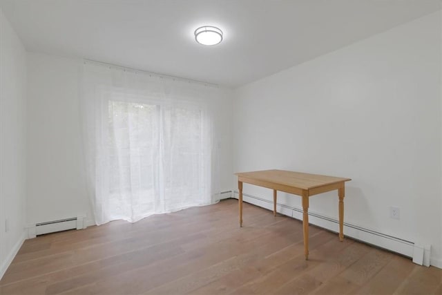 empty room featuring light wood-type flooring and a baseboard radiator