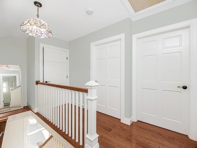 hall featuring hardwood / wood-style floors, lofted ceiling, and crown molding