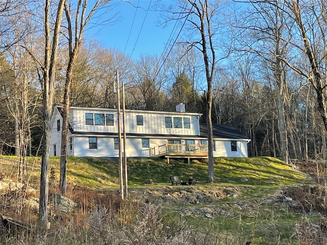 view of front facade featuring a front lawn and a wooden deck