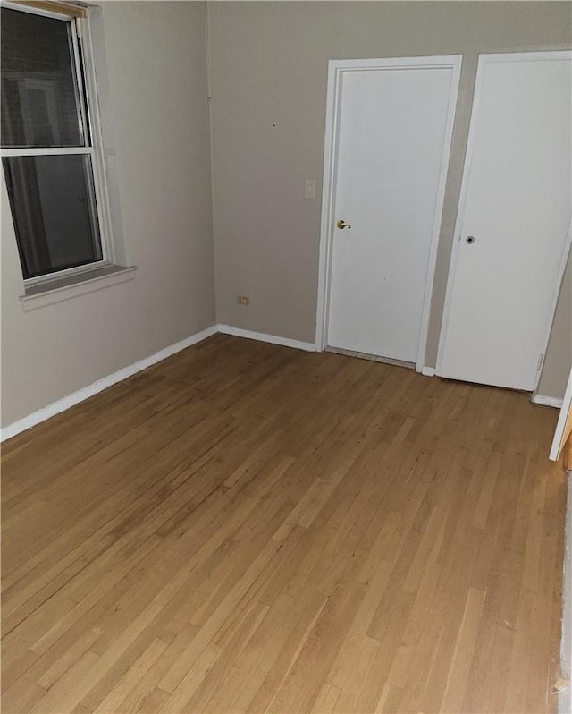 unfurnished bedroom with light wood-type flooring and baseboards