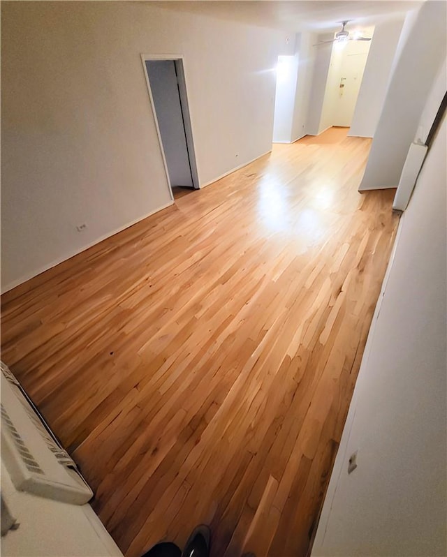 unfurnished room with a ceiling fan and light wood-type flooring