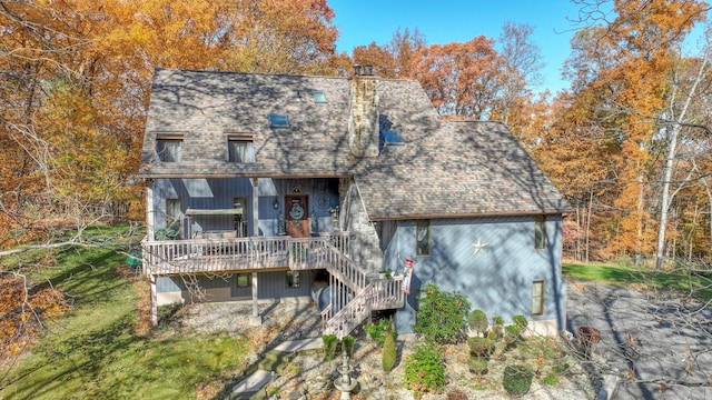 back of house featuring a shingled roof, stairs, and a chimney