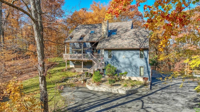 view of front of property featuring a chimney, stairway, and a wooden deck