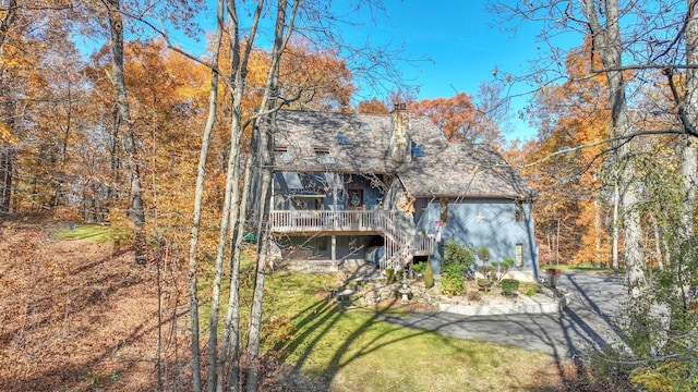 back of property featuring a yard, stairs, a chimney, and a wooden deck