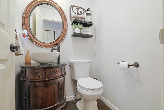 bathroom with toilet, baseboards, and vanity