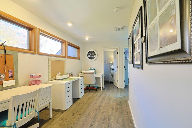 office featuring washer / dryer, light wood-style flooring, visible vents, and baseboards