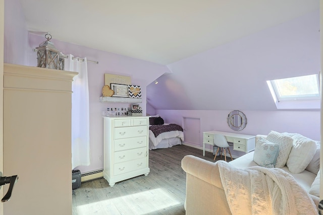 bedroom with a baseboard heating unit, vaulted ceiling with skylight, and wood finished floors