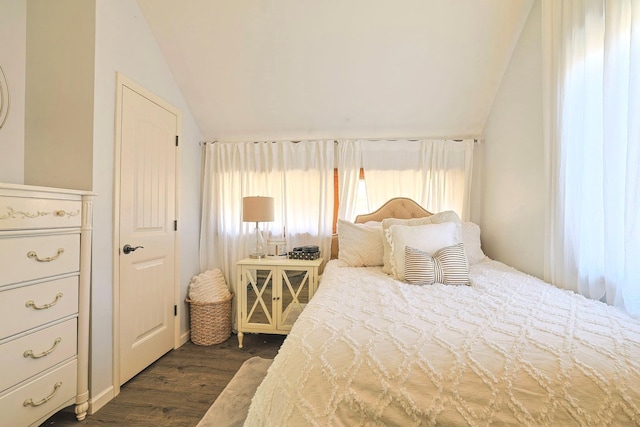 bedroom with dark wood-type flooring, lofted ceiling, and multiple windows