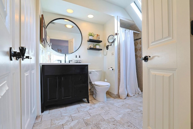 full bath with curtained shower, stone finish flooring, vanity, and toilet