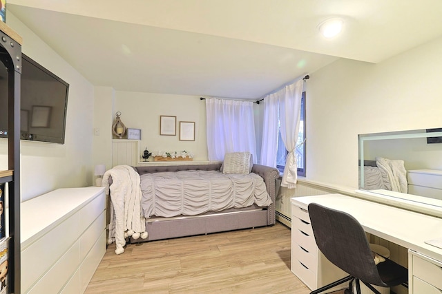 bedroom featuring a baseboard radiator and light wood-style flooring