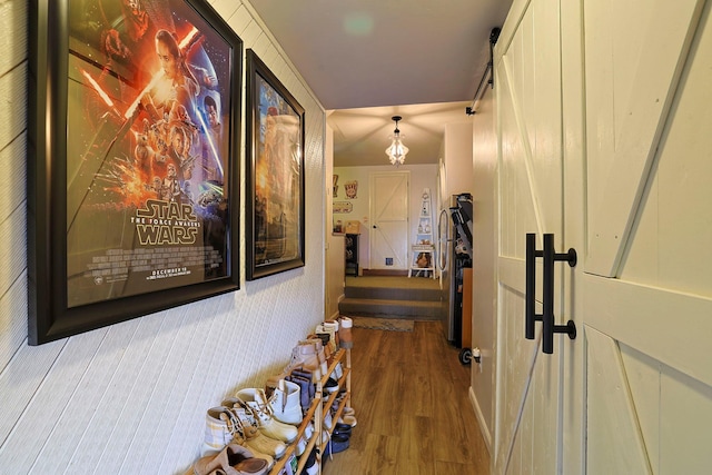 hall featuring a barn door and wood finished floors