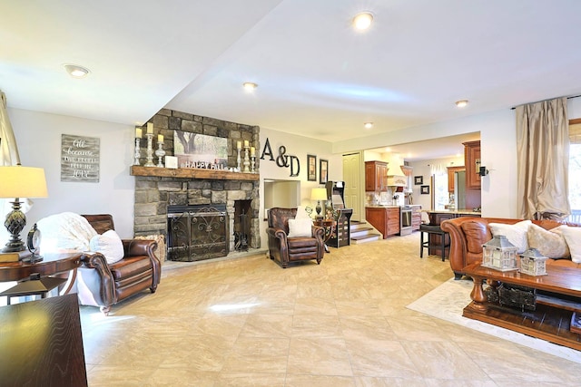 living room featuring stairs and a stone fireplace