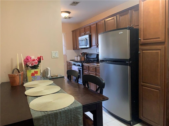 kitchen with appliances with stainless steel finishes and light tile patterned floors