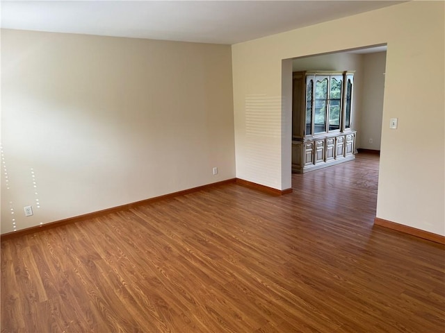 unfurnished room with dark hardwood / wood-style floors