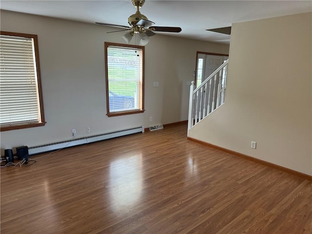 unfurnished room featuring dark hardwood / wood-style flooring, baseboard heating, and ceiling fan