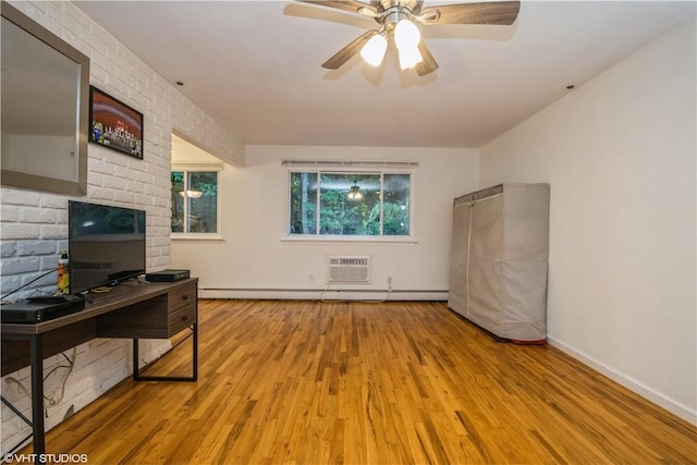 living room featuring ceiling fan, a wall unit AC, brick wall, and light hardwood / wood-style flooring