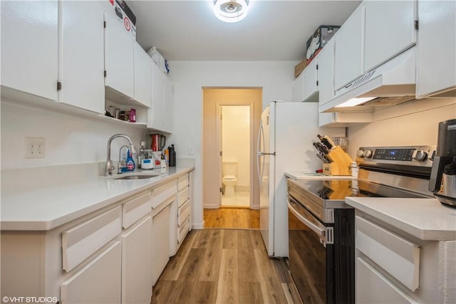 kitchen with white cabinetry, sink, light hardwood / wood-style flooring, premium range hood, and electric stove