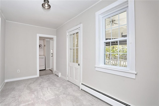 interior space with light carpet, washer / dryer, and baseboard heating